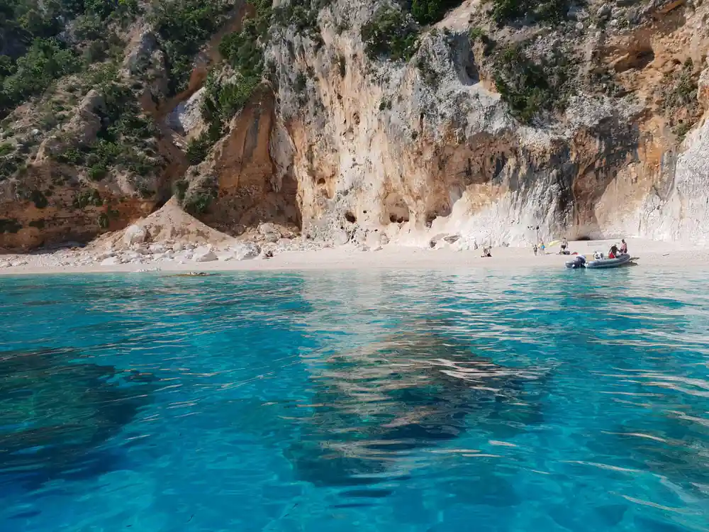 Beach cove with turquoise water and limestone cliff cave overhang