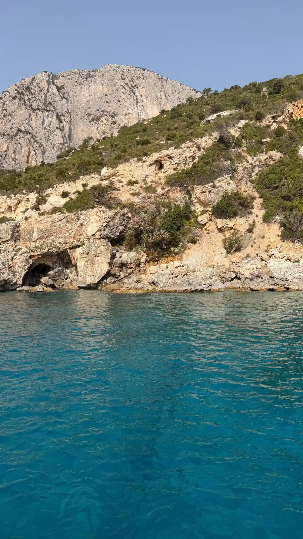 Limestone cliff coastline with turquoise water and vegetation