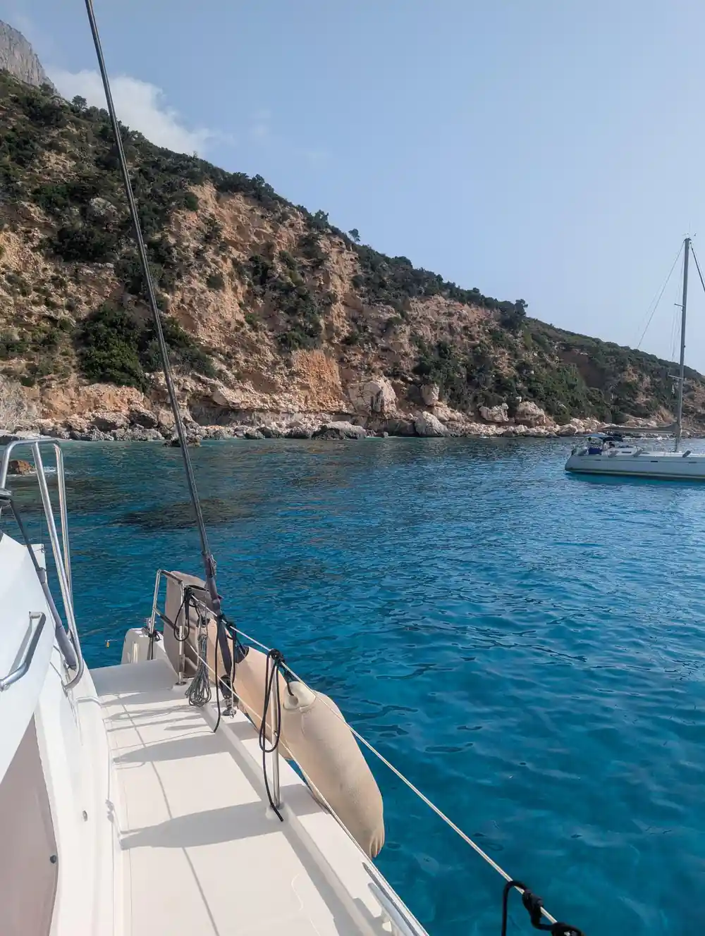 Sailboat anchored in cove with limestone cliffs