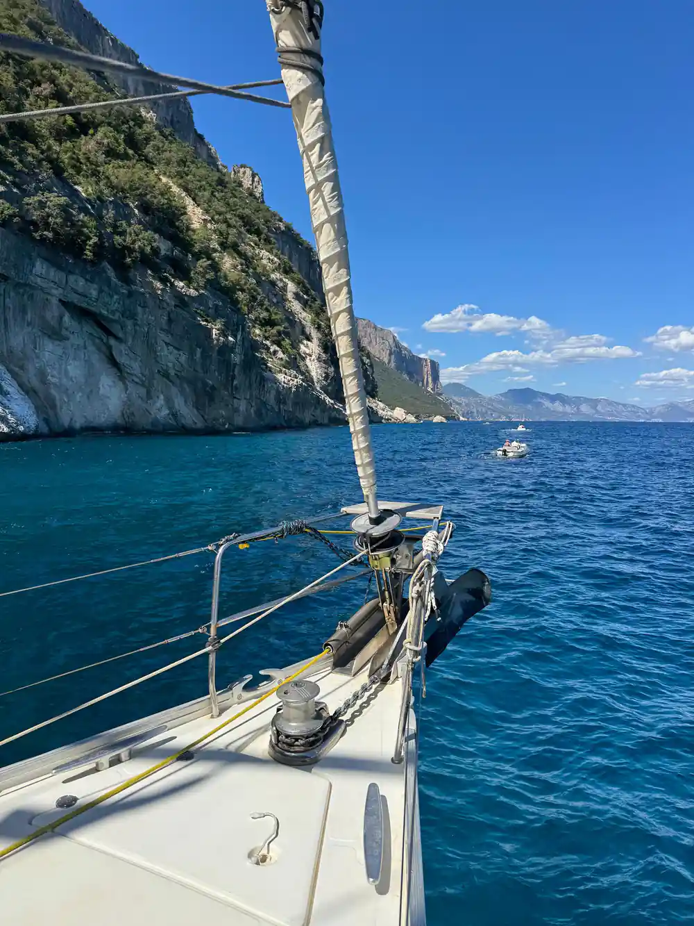 Sailboat bow with rope near rocky limestone cliffs