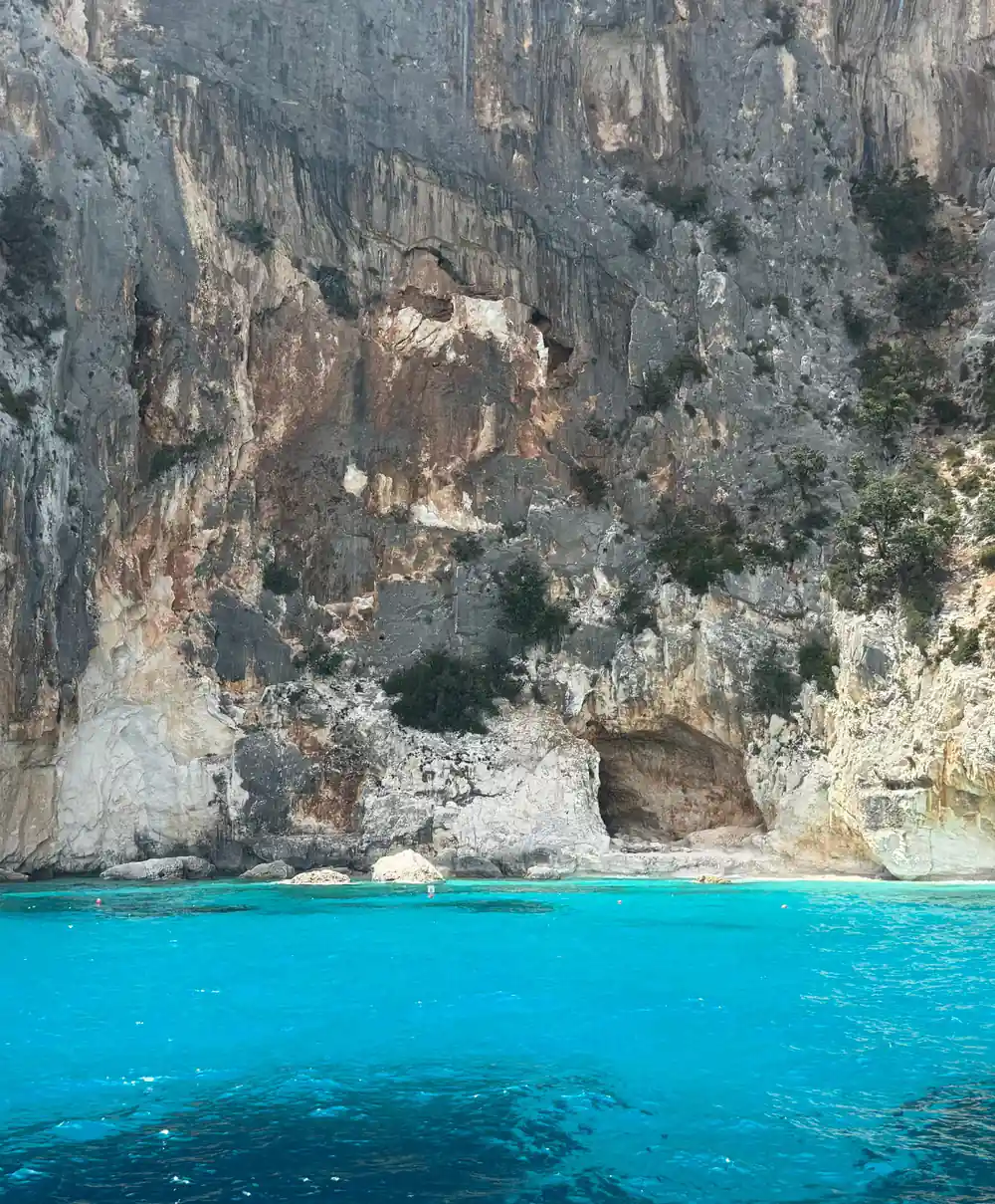 Tall limestone cliff face rising from turquoise sea water