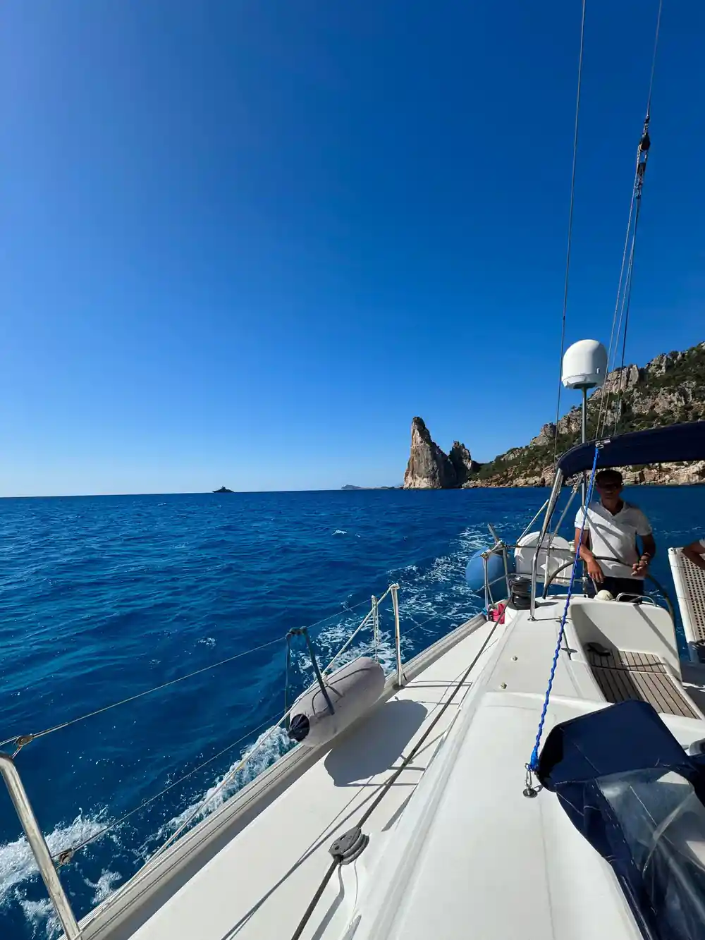 Tall rocky pinnacle viewed from anchored boat in calm sea