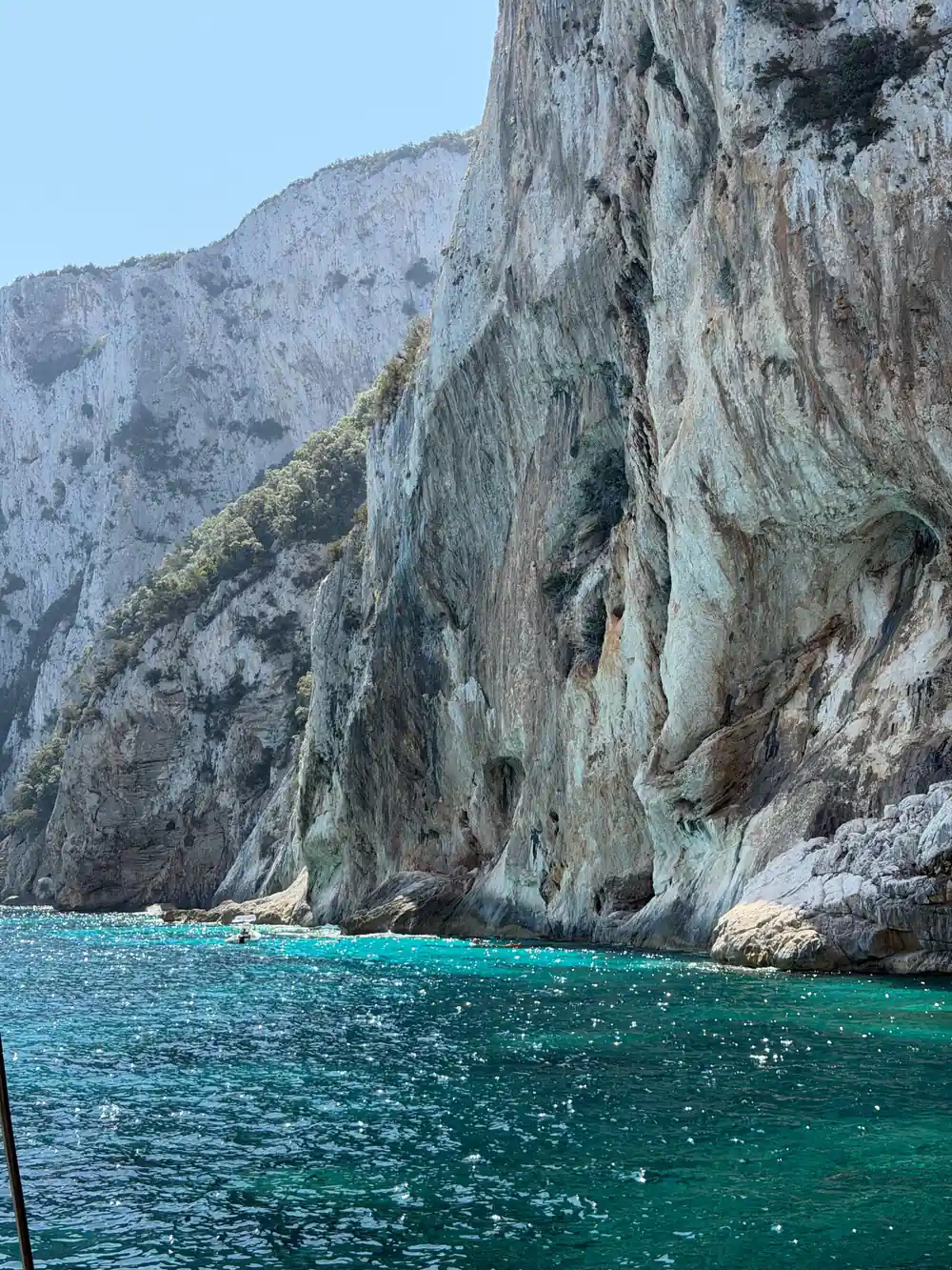Tall white limestone cliff face rising from turquoise sea
