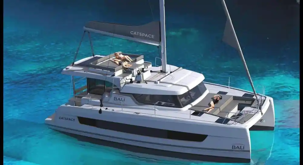 White catamaran anchored in shallow turquoise Mediterranean water