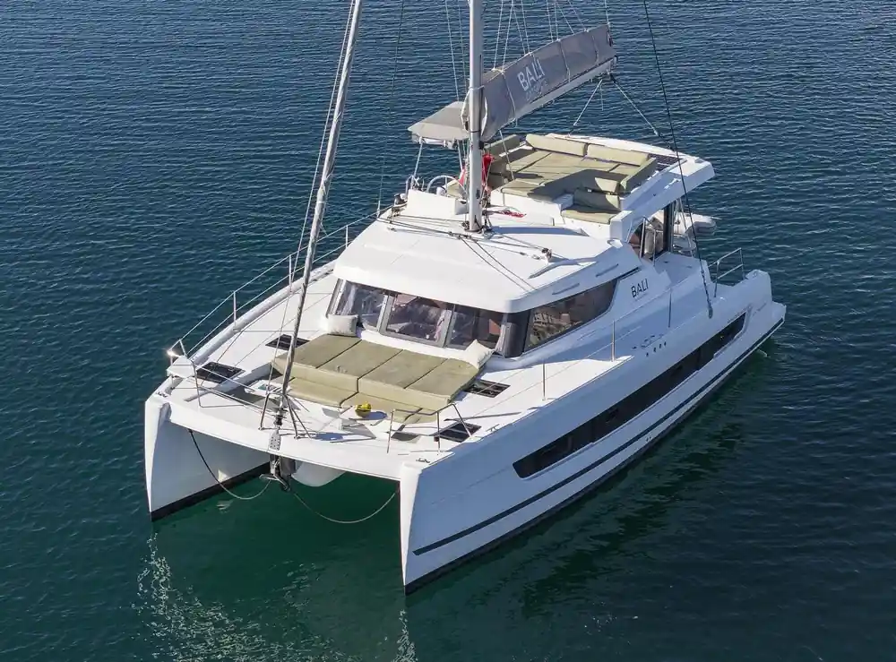 White catamaran sailboat moored in calm turquoise bay